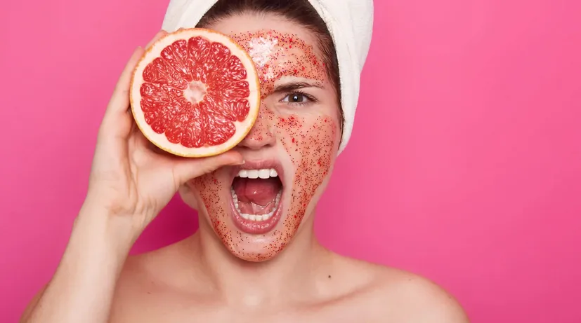 dívka s grapefruitem a peelingem na tváři