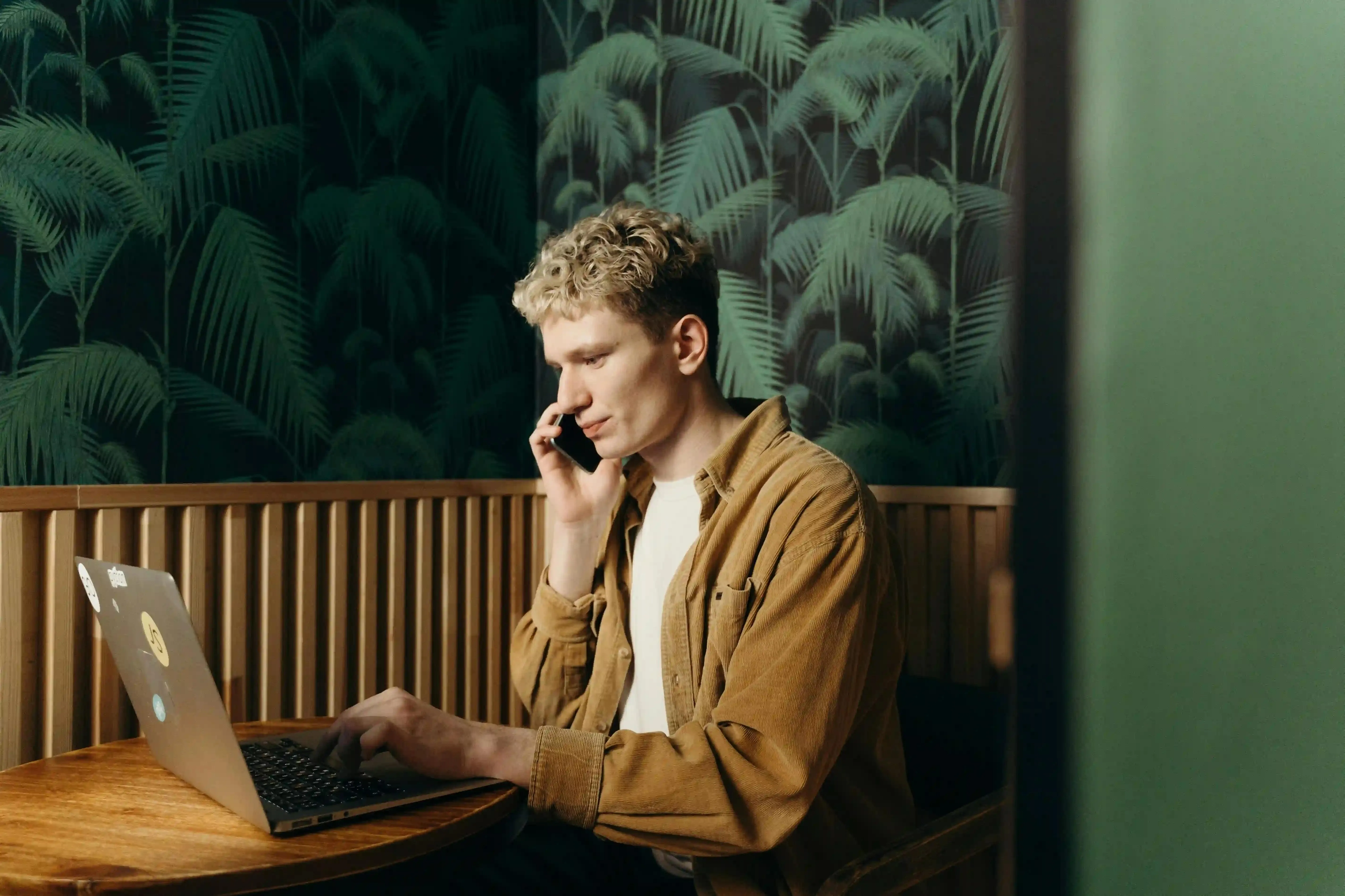 muž v práci, řeší telefonát s klientem